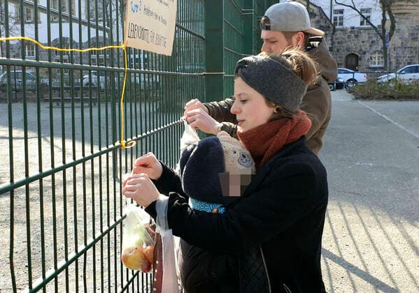 Gabenzaun Chemnitz 26.03.2020, Chemnitz, Corona- Virus, Pandemie, Gabenzaun Volker und Lisa- Mareike Braumüller spazierten heute nach dem gemeinsamen Frühstück zum Andre- Platz, um einige Sachen an den Gabenzaun zu hängen. An den Gabenzaun können Lebensmittel, Kleidung und andere Sachen gehangen werden, als Spenden für Obdachlose Menschen, die es in Zeiten des Corona- Virus besonders schwer haben. Lisa- Mareike Braumüller beteiligt sich auch am Food- Sharing, wo Lebensmittel vor dem Verfallsdatum an soziale Einrichtungen oder andere Personen abgegeben werden. Chemnitz Sachsen BRD