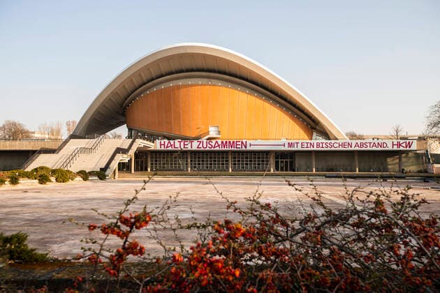 Schrift Haltet Zusammen, mit ein Bisschen Abstand auf dem Haus der Kulturen der Welt in Berlin am 27. Maerz 2020. Um die Verbreitung des Coronavirus (SARS-CoV-2) zu verlangsamen beschlossen Bund und Laender weitere Restriktionen. Nachdem Museen, Theatern, Sportveranstaltungen usw verboten wurden sind seit einigen Tagen weitere verschaerfte Massnahmen in Kraft getreten wie z.B. Verbot von Versammlungen in der Oeffentlichkeit mit mehr als zwei Personen, Einhaltung von Mindestabstand zwischen Personen und Schliessung von Gastronomiebetrieben mit Ausnahme vn Abholung und Lieferung. Oeffentliches Leber weiter in Berlin wegen Coronavirus eingeschraenkt