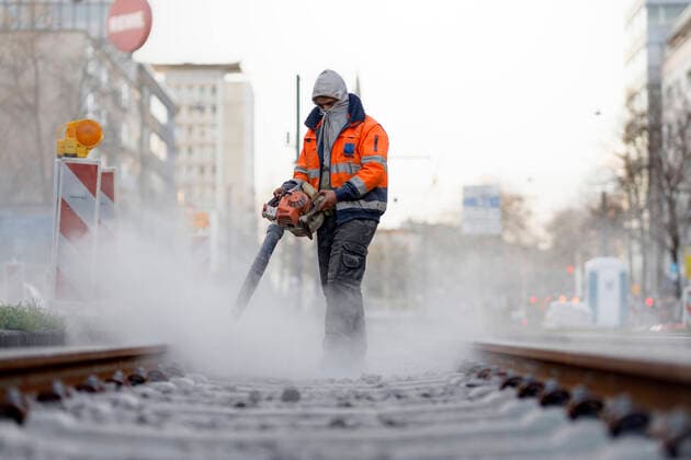 Ein Bauarbeiter bläst Betonstaub von Bahnschienen. Köln, 27.03.2020 Foto:xC.xHardtx xFuturexImage