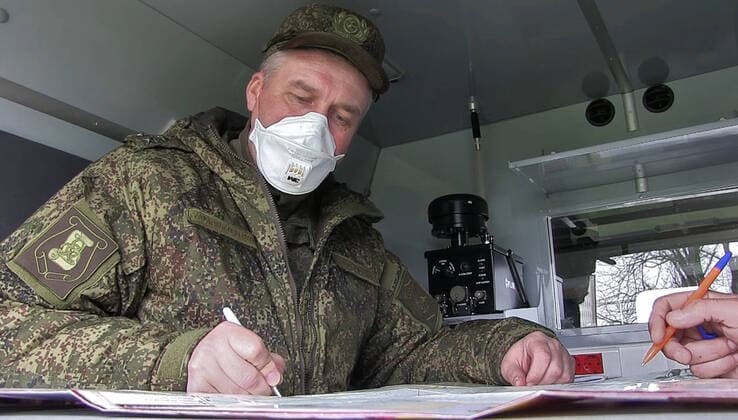 BERGAMO, ITALY - MARCH 27, 2020: Pictured in this video grab is a Russian military officer looking at a map at an Italian Air Force base, on the outskirts of Bergamo in Alpine Lombardy, one of the worst hit regions of Italy during the pandemic of the novel coronavirus (COVID-19). Russia has sent more than 100 military virologists, epidemiologists and CBRN specialists to Italy to help battle the pandemic. Russian military specialists are involved in sanitising and disinfecting healthcare facilities, urban infrastructure, and vehicles. Video grab. Defence Ministry of the Russian Federation TASS  TS0D38D5