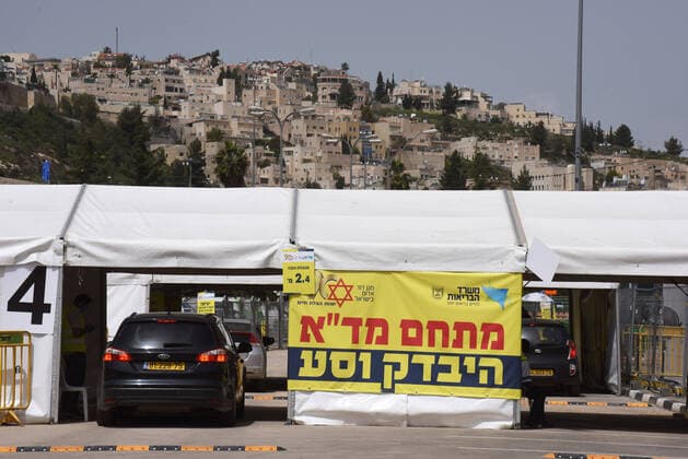 Israelis drive through a coronavirus testing tent in Jerusalem, on Friday, March 27, 2020. Eleven Israelis have died from the coronavirus, while more than 3,000 have been diagnosed with the disease. The Israeli government has imposed tight restrictions of movement, leaving only essential stores open in an effort to stop the spread of the coronavirus.  JER2020032715 DEBBIExHILL