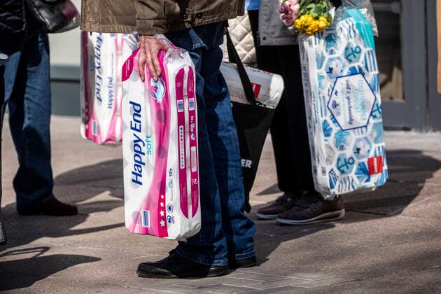 27.03.2020, DU Duisburg , Corona legt Stadtmitte Duisburg lahm , Menschen mit Mundschutz unterwegs , Obdachlose in Gruppen unterwegs , Polizei kontrolliert. Menschen vor einem Supermarkt in der Innenstadt mit Grosspackungen Toilettenpapier in den Händen. Hamsterkauf Hamsterkäufe
