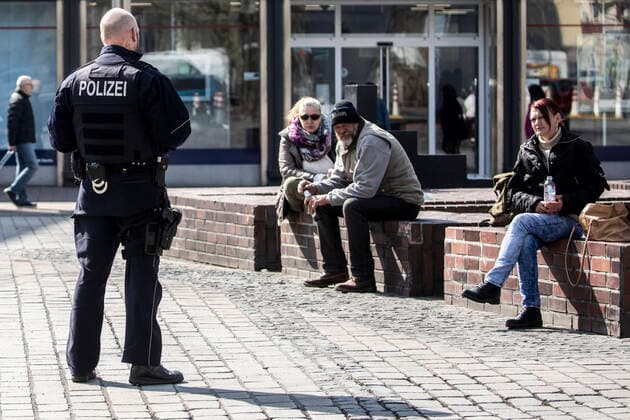 27.03.2020, DU Duisburg , Corona legt Stadtmitte Duisburg lahm , Menschen mit Mundschutz unterwegs , Obdachlose in Gruppen unterwegs , Polizei kontrolliert. Polizei kontrolliert die Obdachlosen am Brunnen am Kuhtor in der Innenstadt.