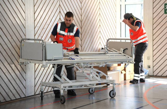 Alte Krankenhausbetten, Nachttische und Zubehör werden am Freitag (27.03.2020) von der Dillinger Marienhausklinik in die Turnhalle vom Max-Planck Gymnasium in Saarlouis gebracht. 17 freiwillige Helfer vom DRK und der Feuerwehren Wadgassen und Ensdorf sind im Einsatz und verlagern die notwendigen Gegenstände. Die Betten werden nur in dieser Sporthalle gelagert, bevor sie dann gegebenenfalls in die Sporthalle nach Lebach und in die Sporthalle an den Fliesen in Saarlouis gebracht werden. Wann das passieren wird ist noch unklar.