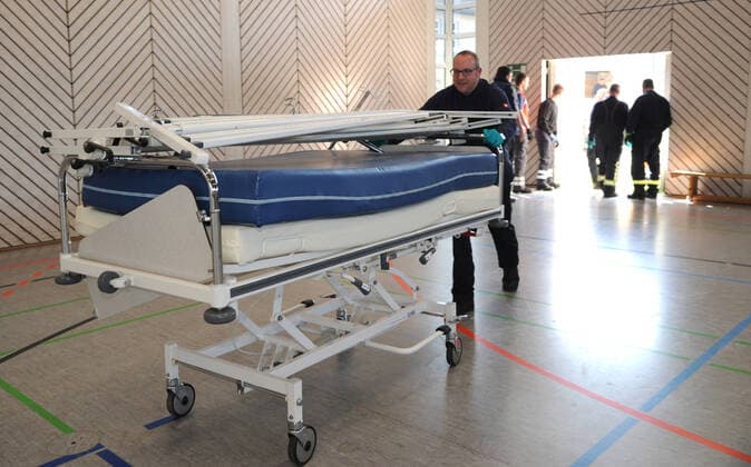 Alte Krankenhausbetten, Nachttische und Zubehör werden am Freitag (27.03.2020) von der Dillinger Marienhausklinik in die Turnhalle vom Max-Planck Gymnasium in Saarlouis gebracht. 17 freiwillige Helfer vom DRK und der Feuerwehren Wadgassen und Ensdorf sind im Einsatz und verlagern die notwendigen Gegenstände. Die Betten werden nur in dieser Sporthalle gelagert, bevor sie dann gegebenenfalls in die Sporthalle nach Lebach und in die Sporthalle an den Fliesen in Saarlouis gebracht werden. Wann das passieren wird ist noch unklar.