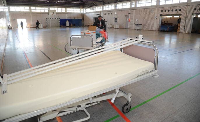 Alte Krankenhausbetten, Nachttische und Zubehör werden am Freitag (27.03.2020) von der Dillinger Marienhausklinik in die Turnhalle vom Max-Planck Gymnasium in Saarlouis gebracht. 17 freiwillige Helfer vom DRK und der Feuerwehren Wadgassen und Ensdorf sind im Einsatz und verlagern die notwendigen Gegenstände. Die Betten werden nur in dieser Sporthalle gelagert, bevor sie dann gegebenenfalls in die Sporthalle nach Lebach und in die Sporthalle an den Fliesen in Saarlouis gebracht werden. Wann das passieren wird ist noch unklar.