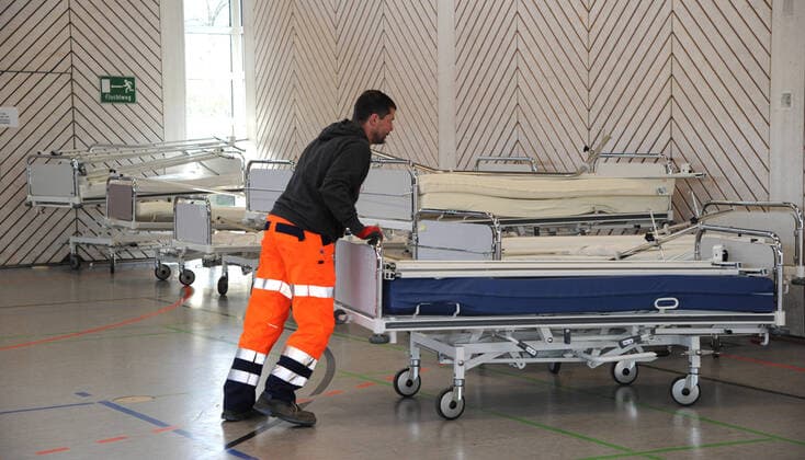 Alte Krankenhausbetten, Nachttische und Zubehör werden am Freitag (27.03.2020) von der Dillinger Marienhausklinik in die Turnhalle vom Max-Planck Gymnasium in Saarlouis gebracht. 17 freiwillige Helfer vom DRK und der Feuerwehren Wadgassen und Ensdorf sind im Einsatz und verlagern die notwendigen Gegenstände. Die Betten werden nur in dieser Sporthalle gelagert, bevor sie dann gegebenenfalls in die Sporthalle nach Lebach und in die Sporthalle an den Fliesen in Saarlouis gebracht werden. Wann das passieren wird ist noch unklar.