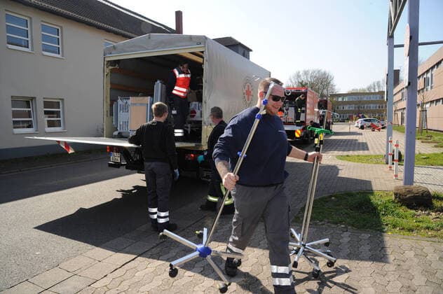 Alte Krankenhausbetten, Nachttische und Zubehör werden am Freitag (27.03.2020) von der Dillinger Marienhausklinik in die Turnhalle vom Max-Planck Gymnasium in Saarlouis gebracht. 17 freiwillige Helfer vom DRK und der Feuerwehren Wadgassen und Ensdorf sind im Einsatz und verlagern die notwendigen Gegenstände. Die Betten werden nur in dieser Sporthalle gelagert, bevor sie dann gegebenenfalls in die Sporthalle nach Lebach und in die Sporthalle an den Fliesen in Saarlouis gebracht werden. Wann das passieren wird ist noch unklar.