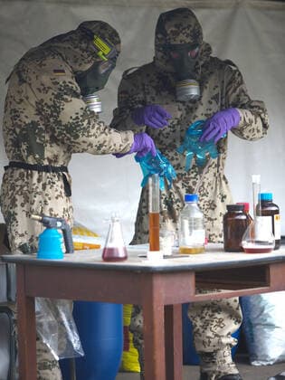 Bundeswehrsoldaten der ABC(atomar, biologisch, chemisch)-Abwehrtruppe bei einer Übung. Die Soldaten spüren Kampfmittel auf, retten unter Sonderschutzbekleidung Personen und Kameraden und dekontanimieren Fahrzeuge, Flächen und Personen. Soldaten der ABC-Abwehrtruppe bei einer Übung auf dem Truppenübungsplatz Bergen am 25.09.2014. Bergen Niedersachsen Deutschland