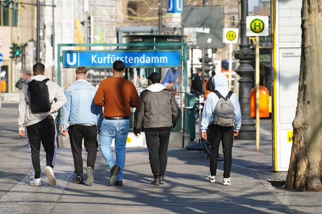 27.03.2020,Berlin,Deutschland,GER,die Stadt in Zeiten der Corona Pandemie, einige Männer halten sich offentlich nicht an die Abstandsreglung. Gesehen auf dem Kurfürstendamm.U-Bahnhof Kurfürstendamm.