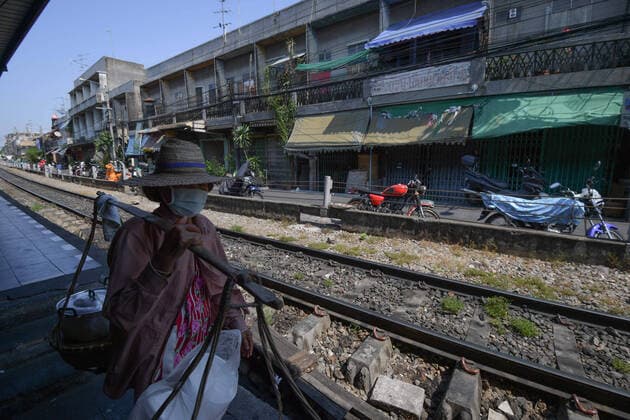 March 27, 2020, Bangkok, Thailand: A hawker wearing a protective face mask as a preventive measure, walking passed an empty train station during the coronavirus (Covid-19) pandemic..Thai government imposed a state of emergency decree that started on March 26, 2020 for the tackle to coronavirus (Covid-19) pandemic. On March 27, 2020 Thai public health ministry reported 91 new cases patients of coronavirus (Covid-19), raising the total to 1,136 and 5 deaths. Bangkok Thailand - ZUMAs197 20200327_zaa_s197_034 Copyright: xVachiraxKalongx