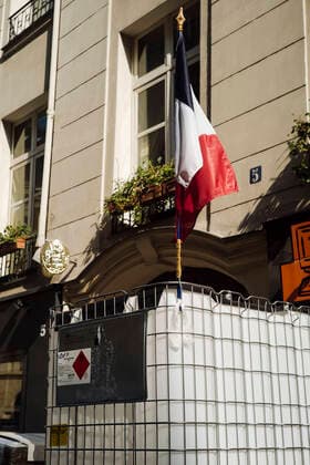 A French flag sits atop a tank of hydroalcoholic gel. For Paul-Eric of the Delpech pharmacy - we do this for France, for others -. Delpech Pharmacy, Paris, France, March 27, 2020.  LouisxWitterx xLexPictorium LePictorium_0226617