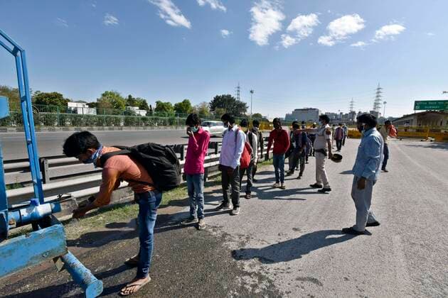 NEW DELHI, INDIA - MARCH 27: Migrant workers clean up as they head home on the third day of national lockdown imposed by Prime Minister Narendra Modi to curb the spread of Coronavirus COVID-19 , at NH 48, Delhi - Gurugram border on March 27, 2020 in New Delhi, India. (Photo by Sanjeev Verma Hindustan Times) Hit By Lockdown, Migrant Workers Walk To Reach Homes