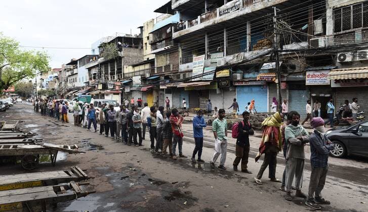 NEW DELHI, INDIA - MARCH 27: Homeless persons and stranded migrant workers queue up to receive food being distributed by Delhi Police, on day 3 of the three week nationwide lockdown to check the spread of Coronavirus COVID-19 , at Khari Baoli on March 27, 2020 in New Delhi, India. (Photo by Vipin Kumar Hindustan Times) Government Provide Food To Homeless And Poor Amid Lockdown To Prevent Covid 19