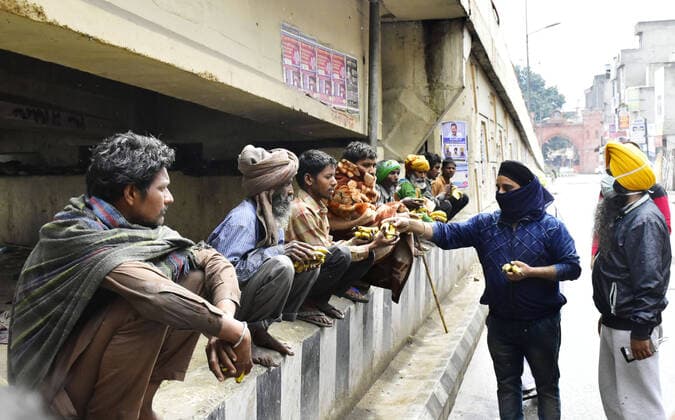 AMRTISAR, INDIA - MARCH 27: Members of Sant Sipahi NGO and Satkar Committee distribute fruit to people near Hall Gate, on day 3 of the three week nationwide lockdown to check the spread of Coronavirus COVID-19 on March 27, 2020 in Amritsar, India. (Photo by Sameer Sehgal Hindustan Times) Government Provide Food To Homeless And Poor Amid Lockdown To Prevent Covid 19