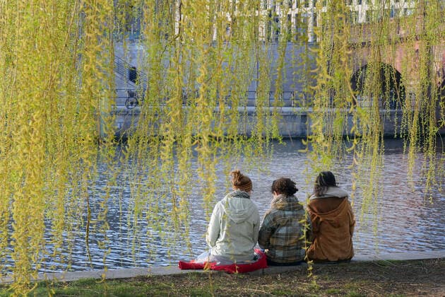 27.03.2020, Berlin - Deutschland: Corona-Krise, diesen drei jungen Frauen ist die Kontaktbeschränkung auf zwei Personen egal, sie genießen das schöne Wetter am Ufer der Spree.