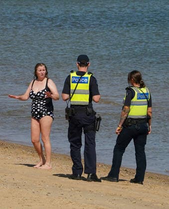 AUSTRALIA CORONAVIRUS COVID-19, Police officers inform beachgoers that the beach is closed at St Kilda Beach in Melbourne, Saturday, March 28, 2020. Port Phillip City Council has clamped down on large groups accessing all of its beaches including the popular St Kilda Beach. A shutdown of non-essential services is in effect Australia wide in a bid to slow the spread of the coronavirus (COVID-19) disease. ( NO ARCHIVING, EDITORIAL USE ONLY, NO USE IN BOOKS WITHOUT CONSENT MELBOURNE VIC AUSTRALIA  Copyright: xSCOTTxBARBOURx 20200328001460556444