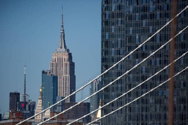 (200328) -- NEW YORK, March 28, 2020 (Xinhua) -- The Empire State building is seen from the Brooklyn Bridge in New York, the United States, on March 27, 2020. The total number of COVID-19 cases in the United States surpassed the mark of 100,000 by Friday afternoon local time, according to Johns Hopkins University. New York State reported 44,870 confirmed cases, followed by the states of New Jersey and California, respectively with 8,825 and 4,569 cases. (Photo by Michael Nagle Xinhua) U.S.-NEW YORK-COVID-19-CONFIRMED CASES