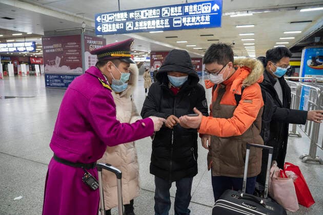 (200328) -- WUHAN, March 28, 2020 -- A staff member helps passengers scan the QR code for real-name registration at the metro station of Wuchang Railway Station in Wuhan, central China s Hubei Province, March 28, 2020. Six metro lines in Wuhan resumed operation starting from Saturday, a new sign that life is gradually returning to normal in the hardest-hit city. Passengers are required to scan the QR code for real-name registration and take temperature checks before taking the subway. Each train is equipped with a train safety crew member to help guide and serve the passengers. ) CHINA-HUBEI-WUHAN-METRO-OPERATION RESTORATION (CN) CaixYang 