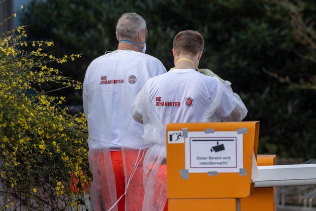 Wuerzburg, Seniorenheim Ehehaltenhaus - St.Nikolaus 28.03.2020, Kohorten-Isolierung wird im Seniorenheim St. Nikolaus vorbereitet Bild: Zwei Pflegekraefte der Johaniter bringen eine Heimbewohnerin auf einem Rollstuhl aus dem Seniorenheim St. Nikolaus Copyright: HMBxMedia xHeikoxBecker
