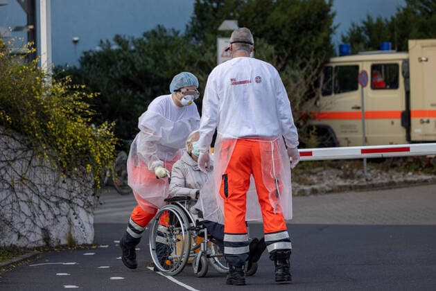 Wuerzburg, Seniorenheim Ehehaltenhaus - St.Nikolaus 28.03.2020, Kohorten-Isolierung wird im Seniorenheim St. Nikolaus vorbereitet Bild: Zwei Pflegekraefte der Johaniter bringen eine Heimbewohnerin auf einem Rollstuhl aus dem Seniorenheim St. Nikolaus Copyright: HMBxMedia xHeikoxBecker