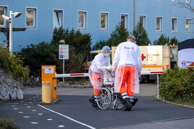 Wuerzburg, Seniorenheim Ehehaltenhaus - St.Nikolaus 28.03.2020, Kohorten-Isolierung wird im Seniorenheim St. Nikolaus vorbereitet Bild: Zwei Pflegekraefte der Johaniter bringen eine Heimbewohnerin auf einem Rollstuhl aus dem Seniorenheim St. Nikolaus Copyright: HMBxMedia xHeikoxBecker