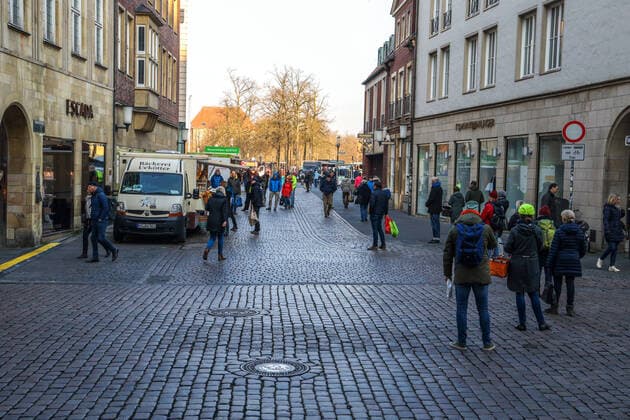 DEU, Deutschland, Nordrhein-Westfalen, Münster, 28.03.2020: Einkaufen auf dem Wochenmarkt - wegen der Corona Ansteckungsgefahr wurde der Wochenmarkt entzerrt, damit zwischen Ständen Freiflächen für wartende Kunden entstehen. Neben dem Domplatz stehen einige Marktstände am Prinzipalmarkt, Auch am Michaelisplatz werden Stände aufgebaut. Der Wochenmarkt ist gut frequentiert und die Abstandsregeln werden von den Kunden beachtet.