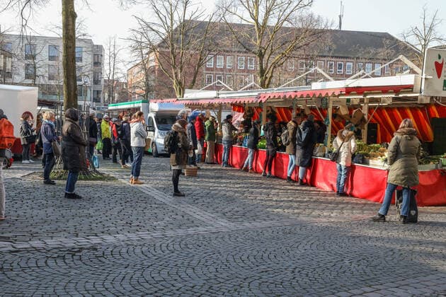 DEU, Deutschland, Nordrhein-Westfalen, Münster, 28.03.2020: Einkaufen auf dem Wochenmarkt - wegen der Corona Ansteckungsgefahr wurde der Wochenmarkt entzerrt, damit zwischen Ständen Freiflächen für wartende Kunden entstehen. Neben dem Domplatz stehen einige Marktstände am Prinzipalmarkt, Auch am Michaelisplatz werden Stände aufgebaut. Der Wochenmarkt ist gut frequentiert und die Abstandsregeln werden von den Kunden beachtet.