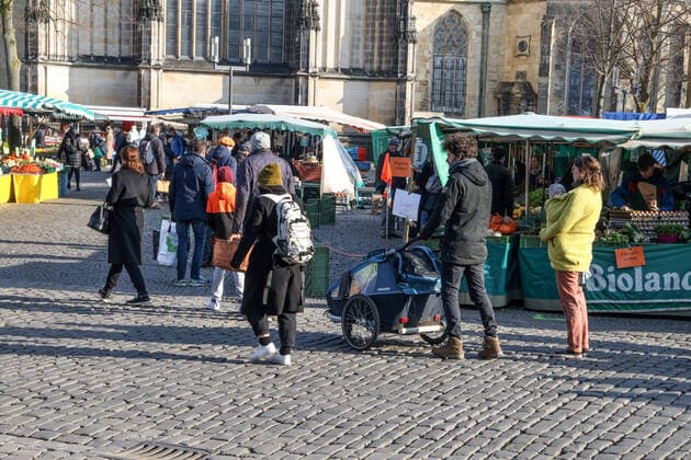 DEU, Deutschland, Nordrhein-Westfalen, Münster, 28.03.2020: Einkaufen auf dem Wochenmarkt - wegen der Corona Ansteckungsgefahr wurde der Wochenmarkt entzerrt, damit zwischen Ständen Freiflächen für wartende Kunden entstehen. Neben dem Domplatz stehen einige Marktstände am Prinzipalmarkt, Auch am Michaelisplatz werden Stände aufgebaut. Der Wochenmarkt ist gut frequentiert und die Abstandsregeln werden von den Kunden beachtet.