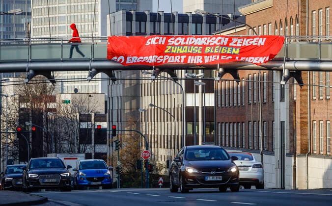 27.03.2020, Essen, Ruhrgebiet, Nordrhein-Westfalen, Deutschland - Coronakrise, ein Transparent fordert ZUHAUSE BLEIBEN, Alfredstrasse B224. Essen Nordrhein-Westfalen Deutschland