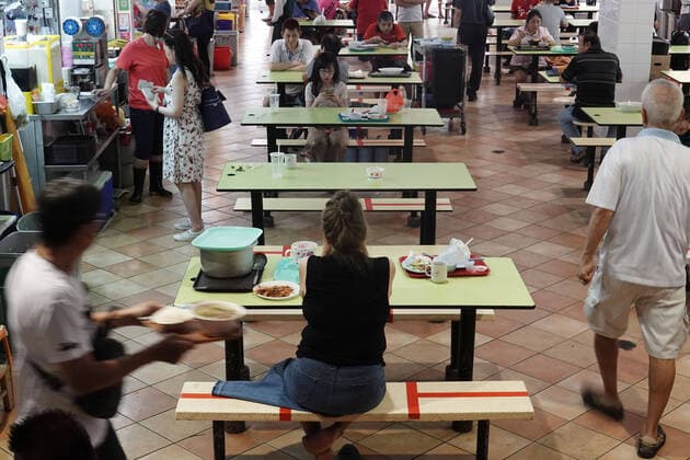 (200328) -- SINGAPORE, March 28, 2020 (Xinhua) -- A hawker center implements social distancing measures by marking seats with red tapes in Singapore Bugis area on March 28, 2020. (Photo by Then Chih Wey Xinhua) SINGAPORE-COVID-19-SOCIAL DISTANCING 