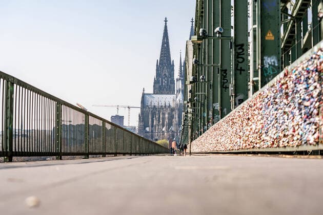 Fast Menschenleere Hohenzollernbrücke Beinahe Menschen leere Hohenzollernbrücke an einem Samstag Mittag mit strahlendem Sonnenschein und angenehmen Temperaturen. Wo sonst jede Stunde viele hundert Menschen flanieren sind jetzt nur wenige dutzend unterwegs. Während der Corona Krise bleiben die meisten Menschen, trotz schönem Wetter, zuhause. Köln Hohenzollernbrücke NRW Deutschland