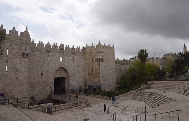 Few Palestinians outside the Damascus Gate to Jerusalem s Old City, in compliance with coronavirus movement restrictions, on Saturday, March 28, 2020. The Israeli government has imposed tight restrictions of movement, leaving only essential stores open in an effort to stop the spread of the coronavirus disease.  JER2020032805 DEBBIExHILL