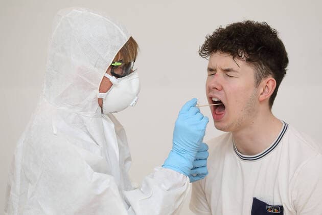 28.03.2020, Berlin, GER - Gestellte Szene: Junger Mann unterzieht sich einem Coronavirus-Test. (MR=yes, 20-30 Jahre, 40-50 Jahre, Abstrich, Aerztin, Alltag, Atemmaske, Berlin, Corona-Schnelltest, Corona-Test, Coronaepidemie, Coronainfektion, Coronapandemie, Coronavirus, Coronavirus-Schnelltest, Coronavirus-Test, Covid 19, Covid-19, deutsch, Deutschland, Europa, europaeisch, Frau, Freisteller, gestellte Szene, Infektion, Infektionsschutz, innen, Innenaufnahme, Kaukasier, kaukasisch, Mann, Menschen, Mundschutz, Patient, Personen, Probeentnahme, QF, Querformat, Schutzbrille, Schutzkleidung, Studio, Studioaufnahme, testen, Testroehrchen, Wattestaebchen, Westeuropa, Wirtschaft) 200328D055BERLIN.JPG