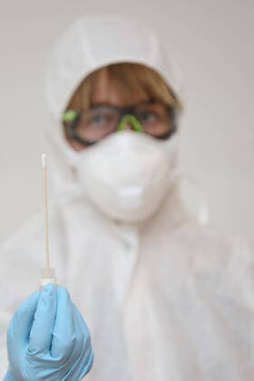28.03.2020, Berlin, GER - Gestellte Szene: Aerztin haelt ein Wattestaebchen eines Coronavirus-Tests in der Hand. (MR=yes, 40-50 Jahre, Aerztin, Alltag, Atemmaske, Berlin, Corona-Schnelltest, Corona-Test, Coronaepidemie, Coronainfektion, Coronapandemie, Coronavirus, Coronavirus-Schnelltest, Coronavirus-Test, Covid 19, Covid-19, deutsch, Deutschland, Europa, europaeisch, Frau, Freisteller, gestellte Szene, HF, Hochformat, Infektion, Infektionsschutz, innen, Innenaufnahme, Kaukasierin, kaukasisch, Mensch, Mundschutz, Person, Probeentnahme, schemenhaft, Schutzbrille, Schutzkleidung, Studio, Studioaufnahme, testen, Wattestaebchen, Westeuropa, Wirtschaft) 200328D060BERLIN.JPG