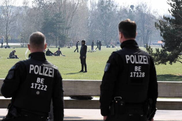 Berliner Polizisten machen Lautsprecherdurchsagen und fordert alle auf, die auf der Wiese sitzen oder liegen, sich zu entfernen. Sport treiben bzw. sich bewegen ist erlaubt. Corona-Streife am Gleisdreieck