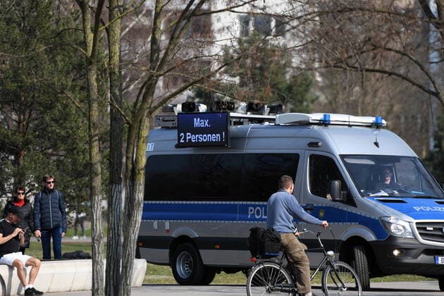 Berliner Polizisten weisen auf die Ausgangs- und Kontaktsperren hin. Zudem machen sie Lautsprecherdurchsagen und fordern alle auf, die auf der Wiese im Park am Gleisdreieck sitzen oder liegen, sich zu entfernen. Sport treiben bzw. sich bewegen ist erlaubt. Corona-Streife am Gleisdreieck