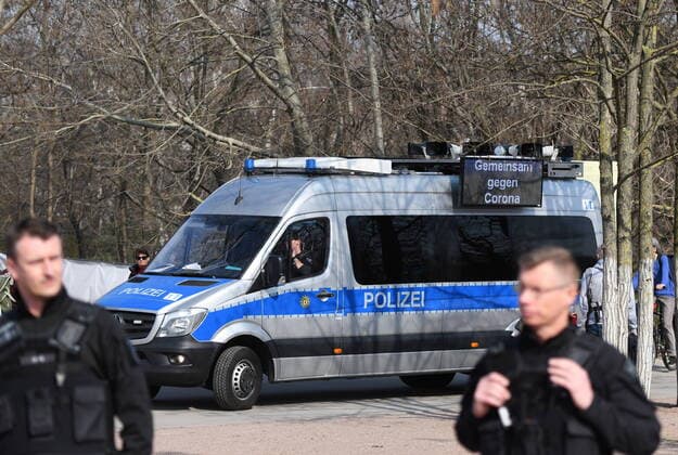 Berliner Polizisten weisen auf die Ausgangs- und Kontaktsperren hin. Zudem machen sie Lautsprecherdurchsagen und fordern alle auf, die auf der Wiese im Park am Gleisdreieck sitzen oder liegen, sich zu entfernen. Sport treiben bzw. sich bewegen ist erlaubt. Corona-Streife am Gleisdreieck