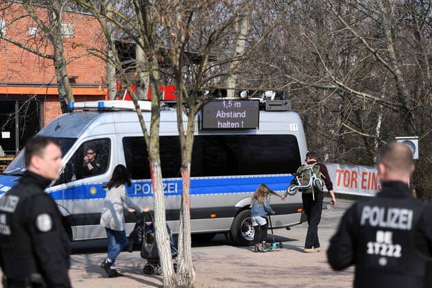 Berliner Polizisten weisen auf die Ausgangs- und Kontaktsperren hin. Zudem machen sie Lautsprecherdurchsagen und fordern alle auf, die auf der Wiese im Park am Gleisdreieck sitzen oder liegen, sich zu entfernen. Sport treiben bzw. sich bewegen ist erlaubt. Corona-Streife am Gleisdreieck