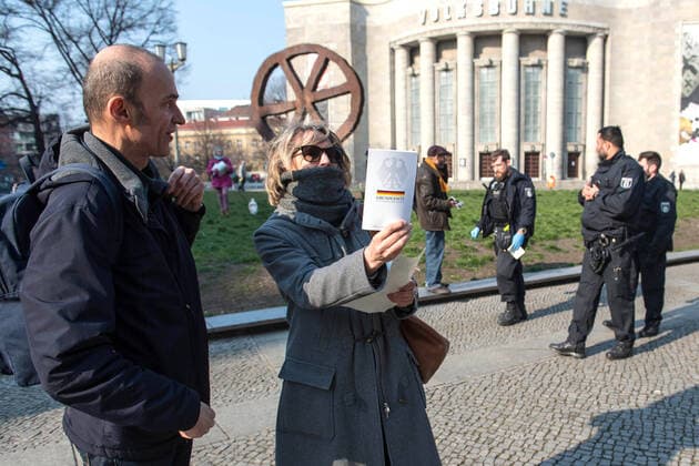 Trotz Ausgangsbeschraenkungen haben am Samstag (28.03.2020) auf dem Rosa-Luxemburg-Platz vor der Berliner Volksbuehne etwa 80 Menschen an einer Hygienedemo fuer Verfassung, Grundrechte & transparente Gestaltung der neuen Wirtschaftsregeln durch die Menschen selbst teilgenommen. Jeweils mit dem Grundgesetz unter dem Arm forderten die Demonstranten im Kreis laufend unter anderem die Beendigung des Notstands-Regimes , demokratische Regeln fuer unser kuenftiges Wirtschaftssystem und die Verhinderung obrigkeitsstaatlicher Schikanen . (Siehe epd-Meldung vom 28.03.2020)