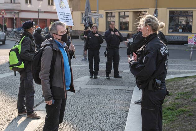 Trotz Ausgangsbeschraenkungen haben am Samstag (28.03.2020) auf dem Rosa-Luxemburg-Platz vor der Berliner Volksbuehne etwa 80 Menschen an einer Hygienedemo fuer Verfassung, Grundrechte & transparente Gestaltung der neuen Wirtschaftsregeln durch die Menschen selbst teilgenommen. (Foto: Die Polizei fordert Demonstranten auf den Platz zu verlassen) Jeweils mit dem Grundgesetz unter dem Arm forderten die Demonstranten im Kreis laufend unter anderem die Beendigung des Notstands-Regimes , demokratische Regeln fuer unser kuenftiges Wirtschaftssystem und die Verhinderung obrigkeitsstaatlicher Schikanen . (Siehe epd-Meldung vom 28.03.2020)