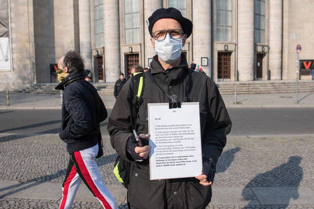 Trotz Ausgangsbeschraenkungen haben am Samstag (28.03.2020) auf dem Rosa-Luxemburg-Platz vor der Berliner Volksbuehne etwa 80 Menschen an einer Hygienedemo fuer Verfassung, Grundrechte & transparente Gestaltung der neuen Wirtschaftsregeln durch die Menschen selbst teilgenommen. Jeweils mit dem Grundgesetz unter dem Arm forderten die Demonstranten im Kreis laufend unter anderem die Beendigung des Notstands-Regimes , demokratische Regeln fuer unser kuenftiges Wirtschaftssystem und die Verhinderung obrigkeitsstaatlicher Schikanen . (Siehe epd-Meldung vom 28.03.2020)