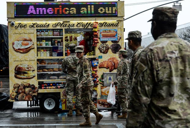 March 28, 2020, New York Manhattan, USA: Army National Guard on the line to buy NYC hot dog out side the The Javits Convention Center. New York Gov. Andrew Cuomo announced the construction of a temporary hospital at the the Jacob K. Javits Center had been completed with the help of FEMA and the National Guard. New York State has over 26,000 cases and 450 people died from the pandemic in NYS in the past 24 hours. 03 28 20. New York Manhattan. . New York Manhattan. USA - ZUMAs252 20200328_znp_s252_018 Copyright: xMarcusxSantosx