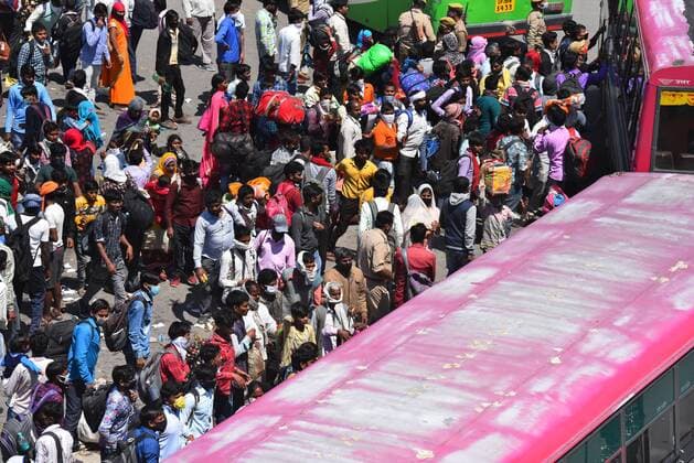 NEW DELHI, INDIA - MARCH 28: A wave of migrant workers try to board a bus bound to their native state at Ghazipur, near the Delhi - UP border on Day 4 of the 21 day nationwide lockdown -- to check the spread of coronavirus, on March 28, 2020 in New Delhi, India. (Photo by Raj K Raj Hindustan Times ) Coronavirus Update: Amid Lockdown, A Sea Of Migrants In Delhi-NCR Try To Find Their Way Back Home