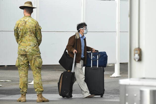 AUSTRALIA CORONAVIRUS COVID-19, A member of the Defence Force watches over as returning overseas travellers are ushered towards waiting busses for the beginning of their 14-day imposed quarantine after arriving at Sydney International Airport in Sydney, Sunday, March 29, 2020. ( NO ARCHIVING, EDITORIAL USE ONLY, NO USE IN BOOKS WITHOUT CONSENT SYDNEY NSW AUSTRALIA  Copyright: xJOELxCARRETTx 20200329001460668571