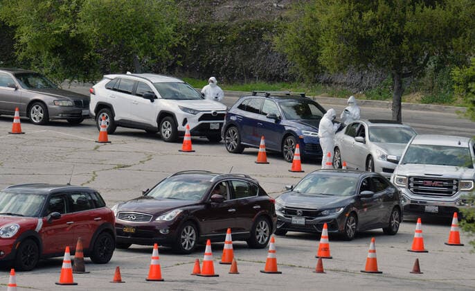 Medical and fire department personnel distribute self-testing coronavirus kits to residents who made appointments, in a parking lot adjacent to Dodger Stadium in Los Angeles on Saturday, March 28, 2020. The number of confirmed cases of COVID-19, the disease caused by the.coronavirus in Los Angeles County stood at 1,465 as of midday Saturday, with 26 deaths. The county s Department of Public Health reported 257 new cases on Friday, and 421 on Thursday, the highest one-day total so far.  LAP2020032806 JIMxRUYMEN