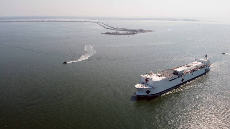 March 28, 2020, Norfolk, Virginia, United States Of America: NORFOLK, VA - MARCH 28: The Military Sealift Command hospital ship USNS Comfort (T-AH 20) departs Naval Station Norfolk, Va., March 28, 2020. Comfort is deploying in support of the nations COVID-19 response efforts and will serve as a referral hospital for non-COVID-19 patients currently admitted to shore-based hospitals. This allows shore-based hospitals to focus their efforts on COVID-19 cases. One of the Department of Defenses missions is Defense Support of Civil Authorities. DoD is supporting the Federal Emergency Management Agency, the lead federal agency, as well as state, local and public health authorities in helping protect the health and safety of the American people on March 28, 2020 in Norfolk, Virginia..People: USNS Comfort Norfolk United States Of America - ZUMAn287 20200328_zaa_n287_003 Copyright: xSMGx
