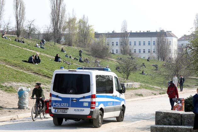 28.03.2020, Berlin - Deutschland: das warme Wochenende zieht die Menschen in der Corona-Krise nach draußen. Die Polizei fährt im Mauerpark Streife. Die Leute befolgen die Regeln und sitzen mit Abstand im Freien in der Sonne.