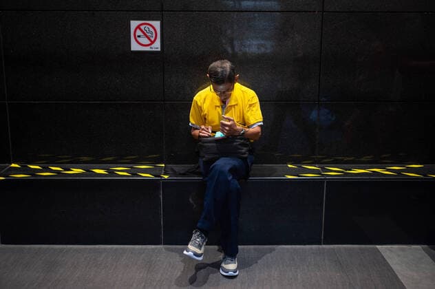 28.03.2020, Singapur, Republik Singapur, Asien - Massnahmen zur Einhaltung von Sicherheitsabstaenden (Safe Distancing) sind eingefuehrt worden, um die Ausbreitung des pandemischen Coronavirus einzuschraenken. Bereiche einer Sitzbank im Stadtteil Ang Mo Kio sind mit schwarz-gelbem Klebeband ueberklebt, damit sich Menschen nicht auf die markierten Flaechen setzen, was zu einer raeumlichen Distanzierung (Social Distancing) fuehrt und somit den direkten Kontakt mit den Sitznachbarn verhindert.