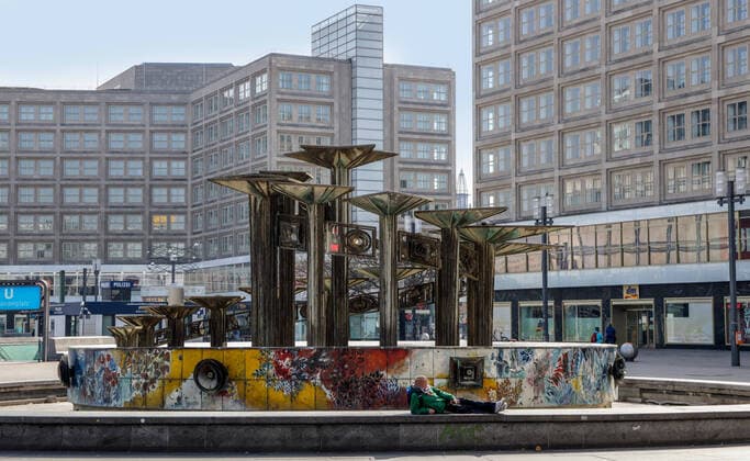 Coronavirus in Berlin Berlin, 27.03.2020, Alexanderplatz. Wegen des Coronavirus zeigt sich der Alexanderplatz ungewoehnlich Menschenleer. Ein Mann sonnt sich am Brunnen der Voelkerfreundschaft. Berlin Berlin Deutschland Alexanderplatz